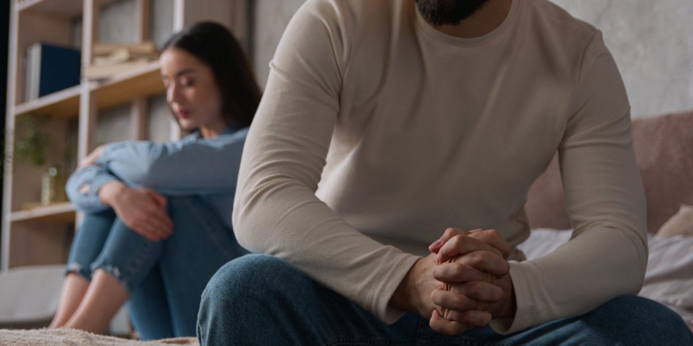 Annoyed Caucasian husband sit apart on bed with offended wife keep silence after fight family quarrel married couple woman man arguing misunderstanding breakup divorce relationship crisis in bedroom