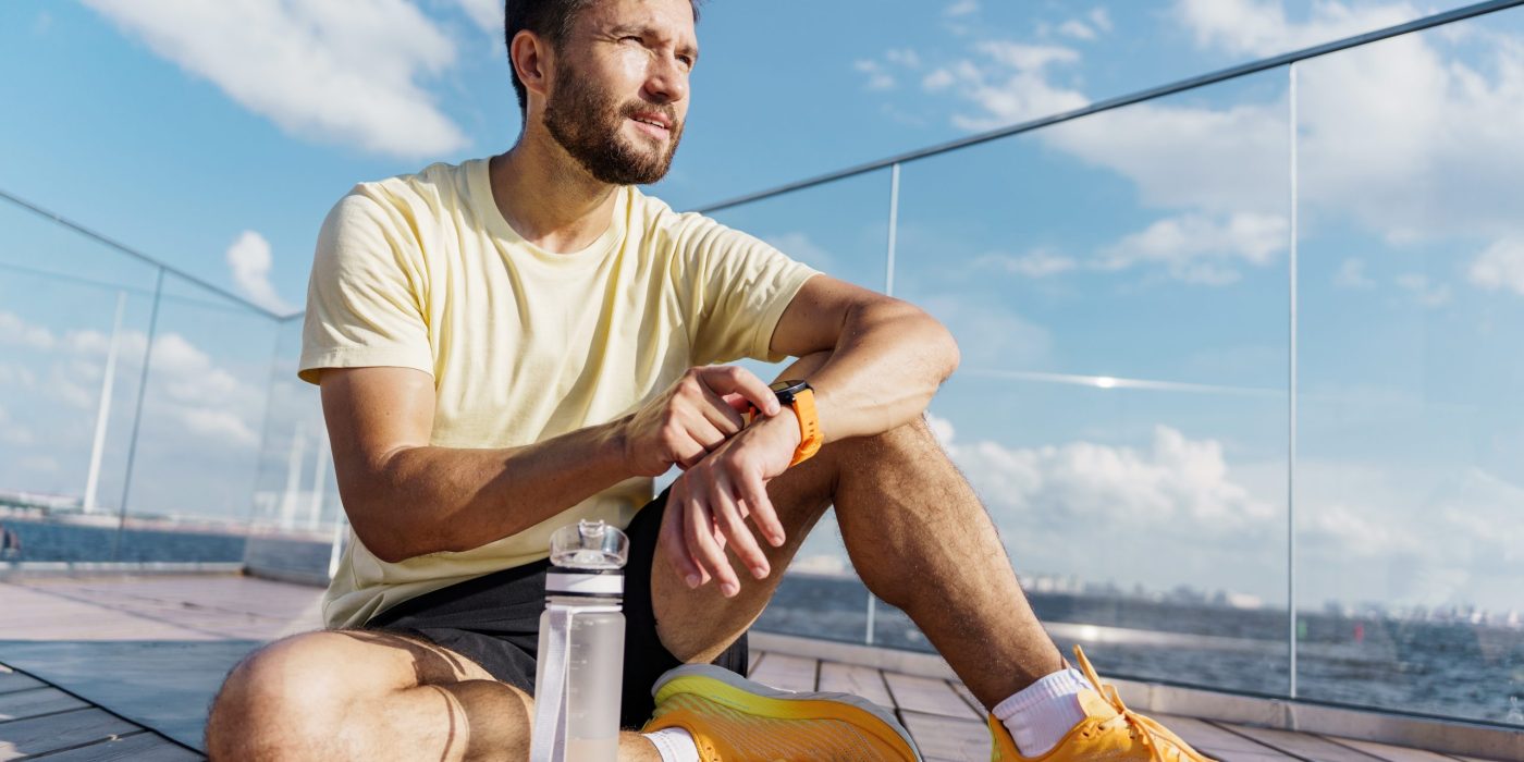 Man applying sunscreen alongside sensitive skin cleanser, anti ageing night cream, and Australian skincare products as part of a daily skincare routine.