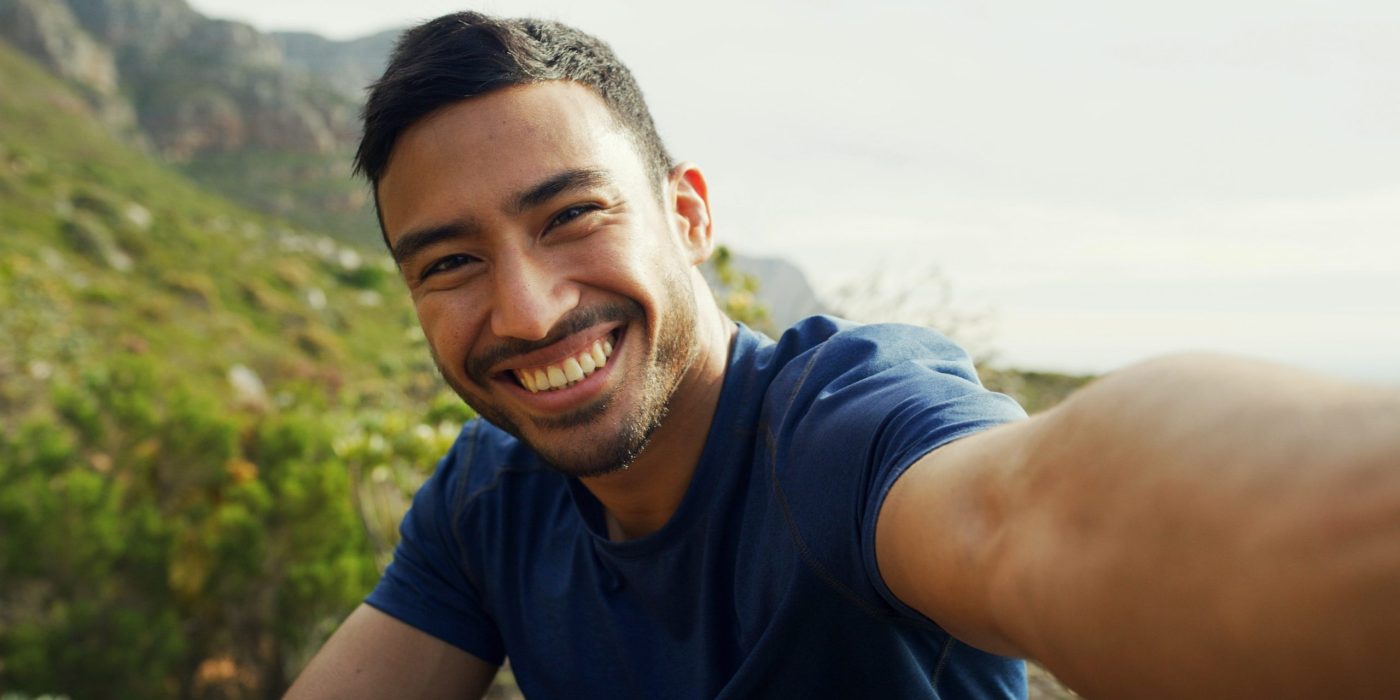 Confident man smiling naturally, highlighting a smile makeover, adult braces, and Invisalign aligner therapy for a balanced, attractive smile.